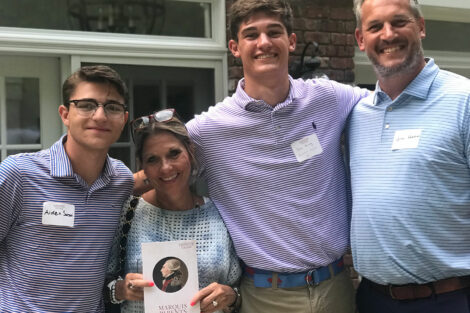 A family poses for a picture holding the Marquis Parents Council brochure outside at the North Jersey Welcome Event