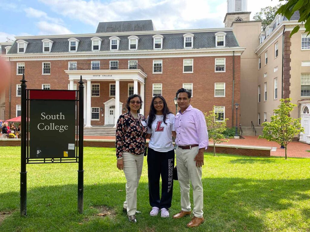 Divya, Pankaj and Nitasha Gupta '26 are standing in front of South College