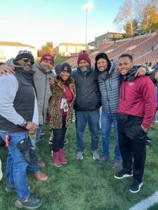 Members of the Brothers of Lafayette with Director of Athletics Sherryta Freeman during the 2022 Rivalry Game. The group is standing on the football field.