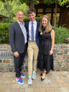 Jason and Nancy Rosenthal P’26, with their son, Andrew. stand outside. Ian is wearing a jacket and tie. Nancy is wearing a black dress. They are smiling at the camera.